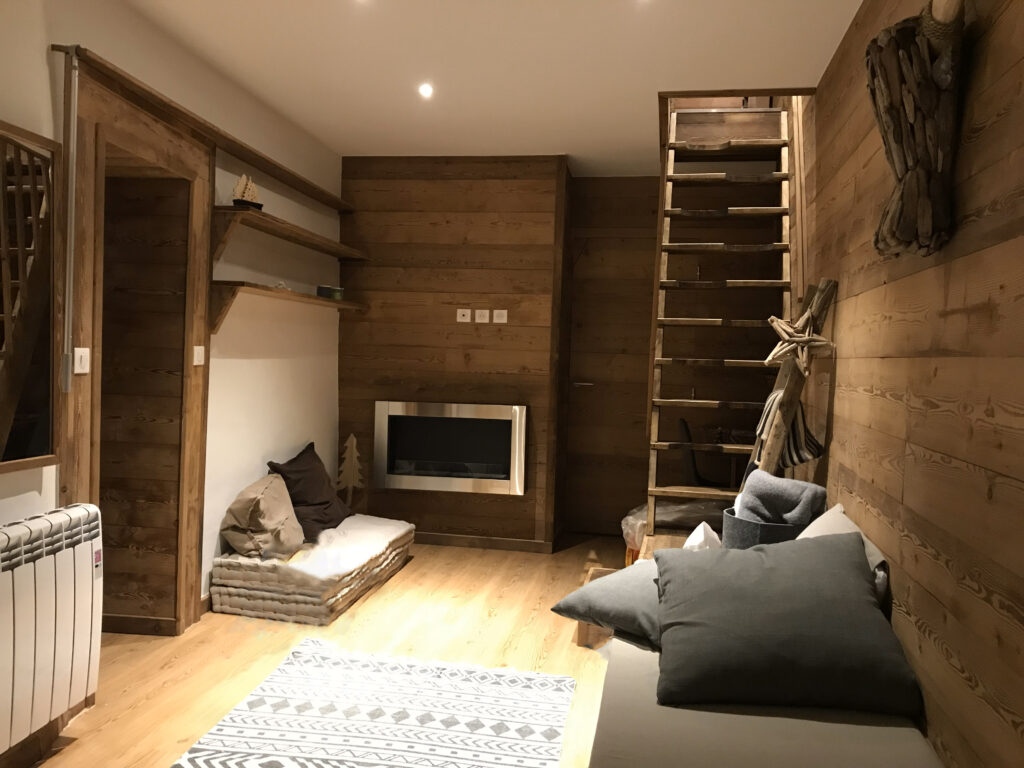 Premier salon avec escalier en bois.