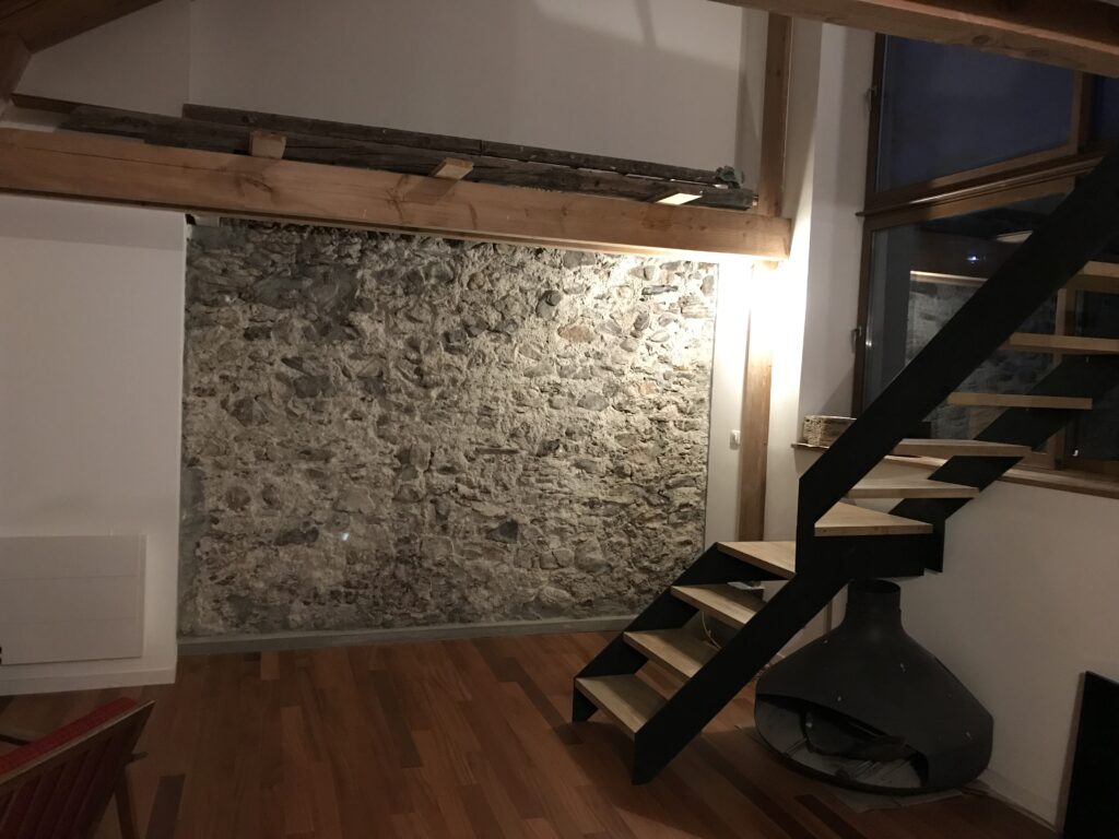 Escalier sur mesure en acier et bois, mur en pierre.